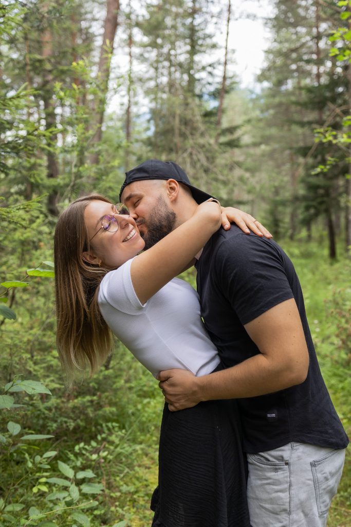 Paar küsst sich umarmend im Wald