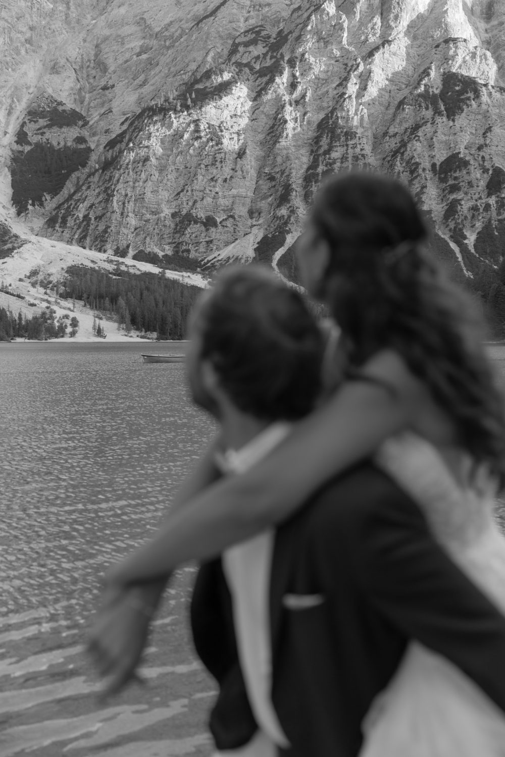 Laura und Tommy in enger Umarmung vor der Bergkulisse (Schwarz-Weiß-Aufnahme)