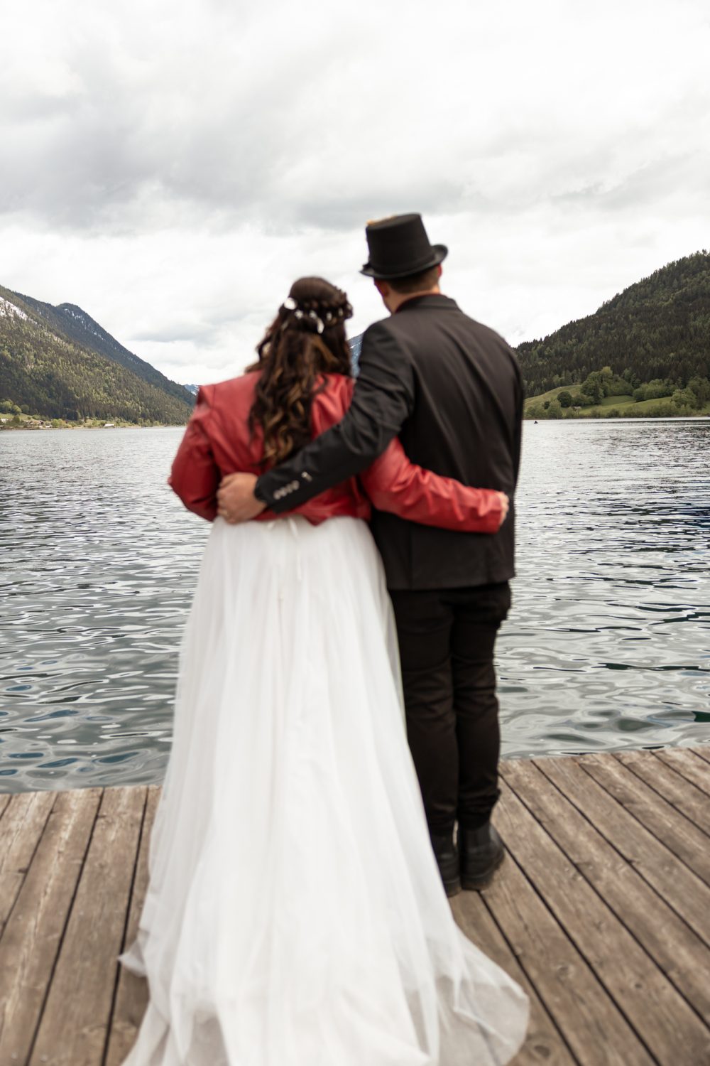 Brautpaar von hinten auf einem Holzsteg am See (Beispielbild)