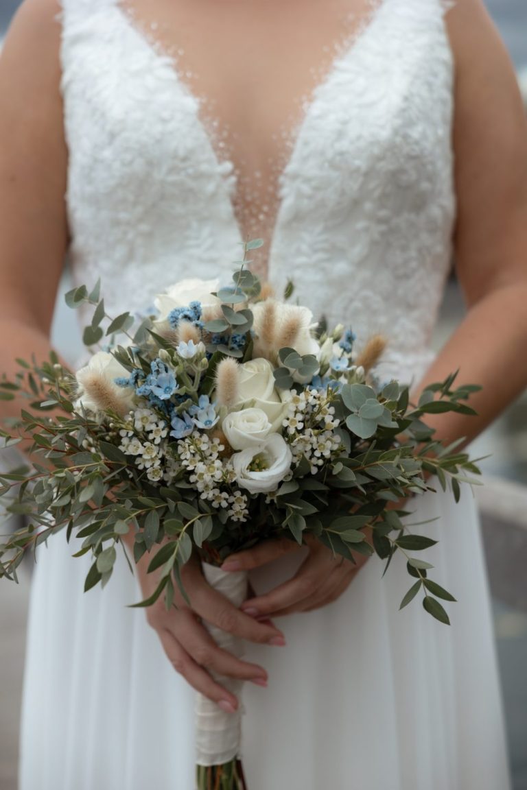 Braut hält einen Strauß mit weißen und blauen Blüten